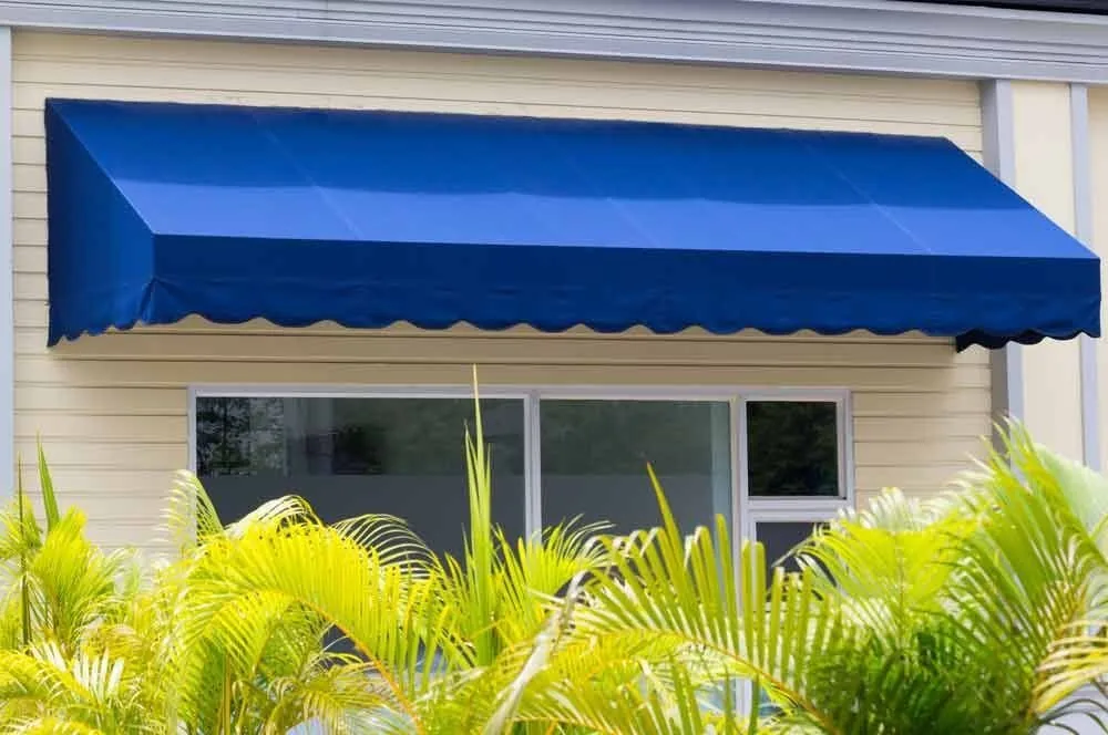 Blue awning fitted above a white framed window