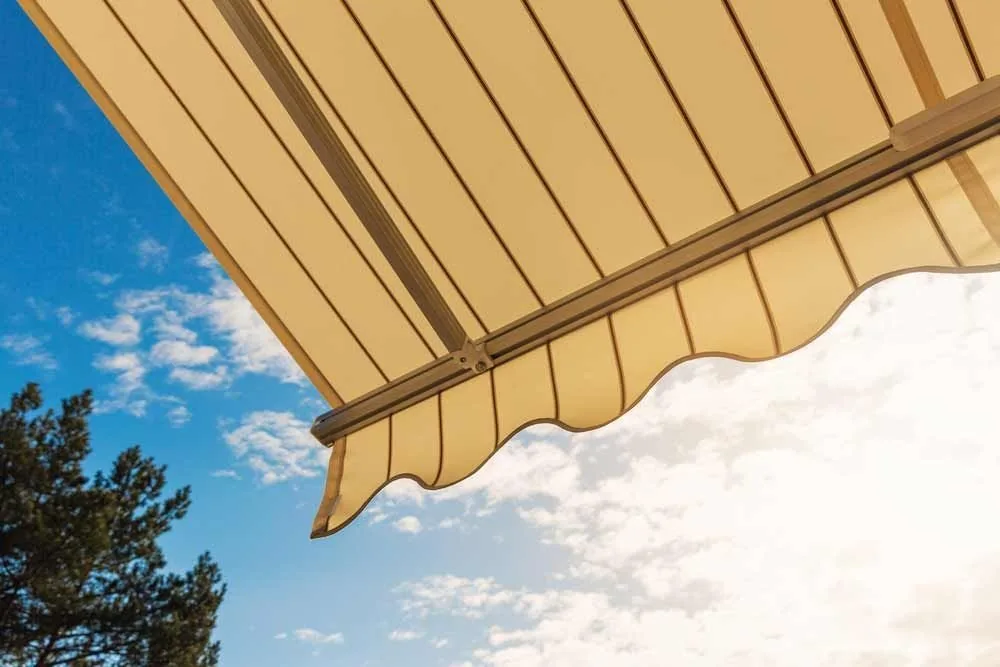 Yellow awning fabric seen from below against a clear sky