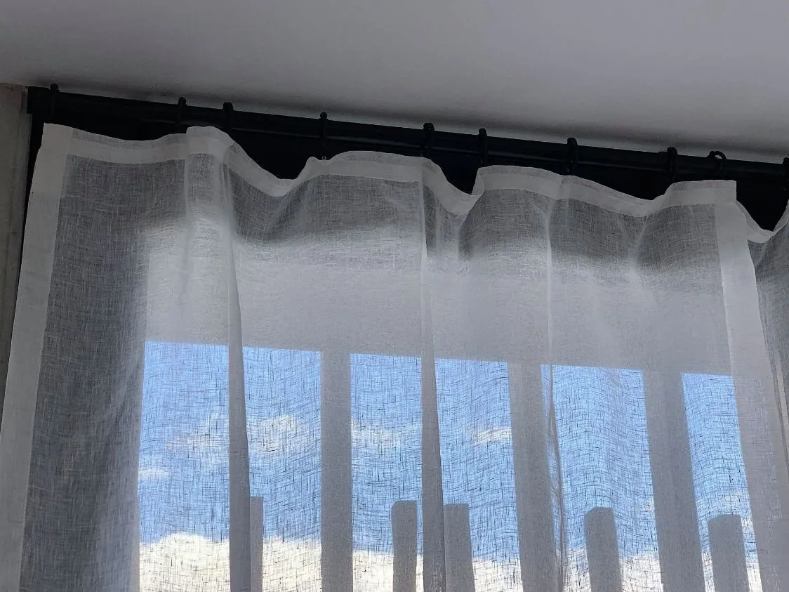 Wide linen curtains drawn back across a living area