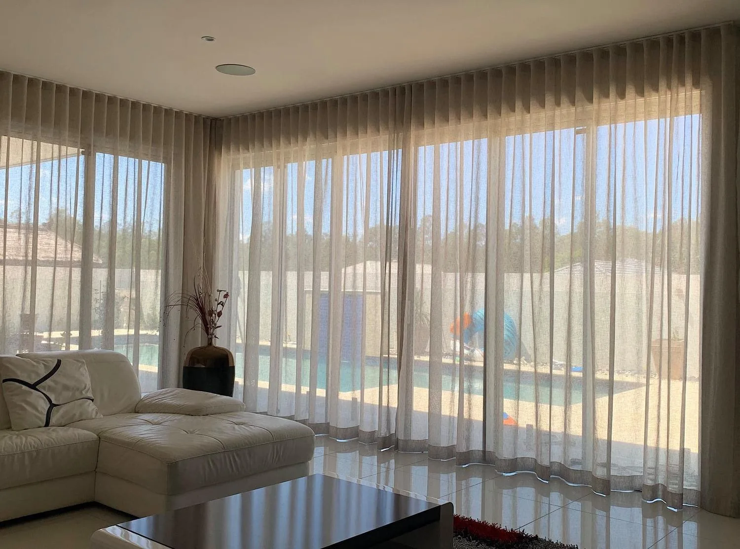S-fold sheer curtains hanging in even waves across a living room window