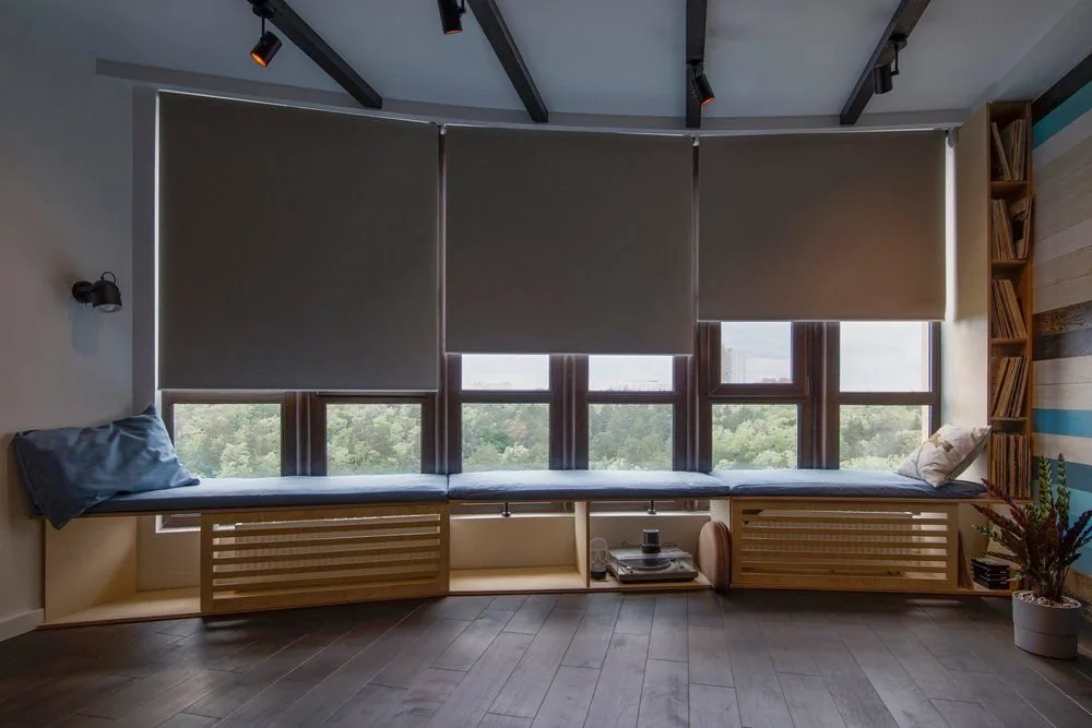 Motorised blinds lowered together across a run of windows