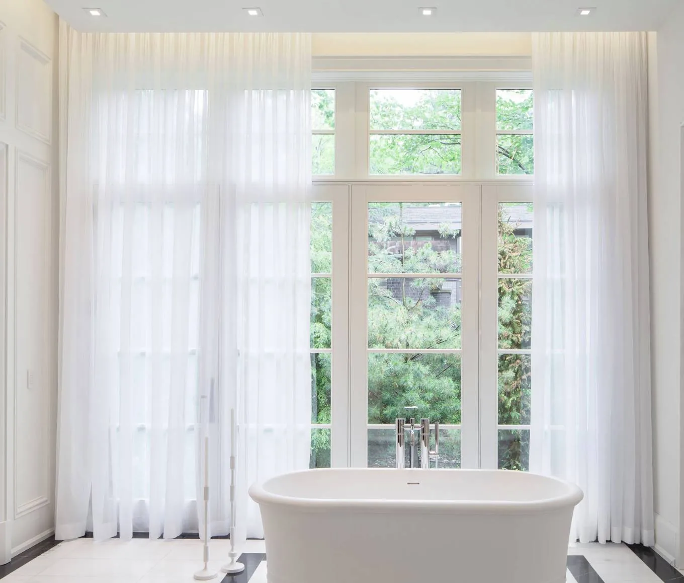 Sheer curtains on a motorised track across tall bathroom windows