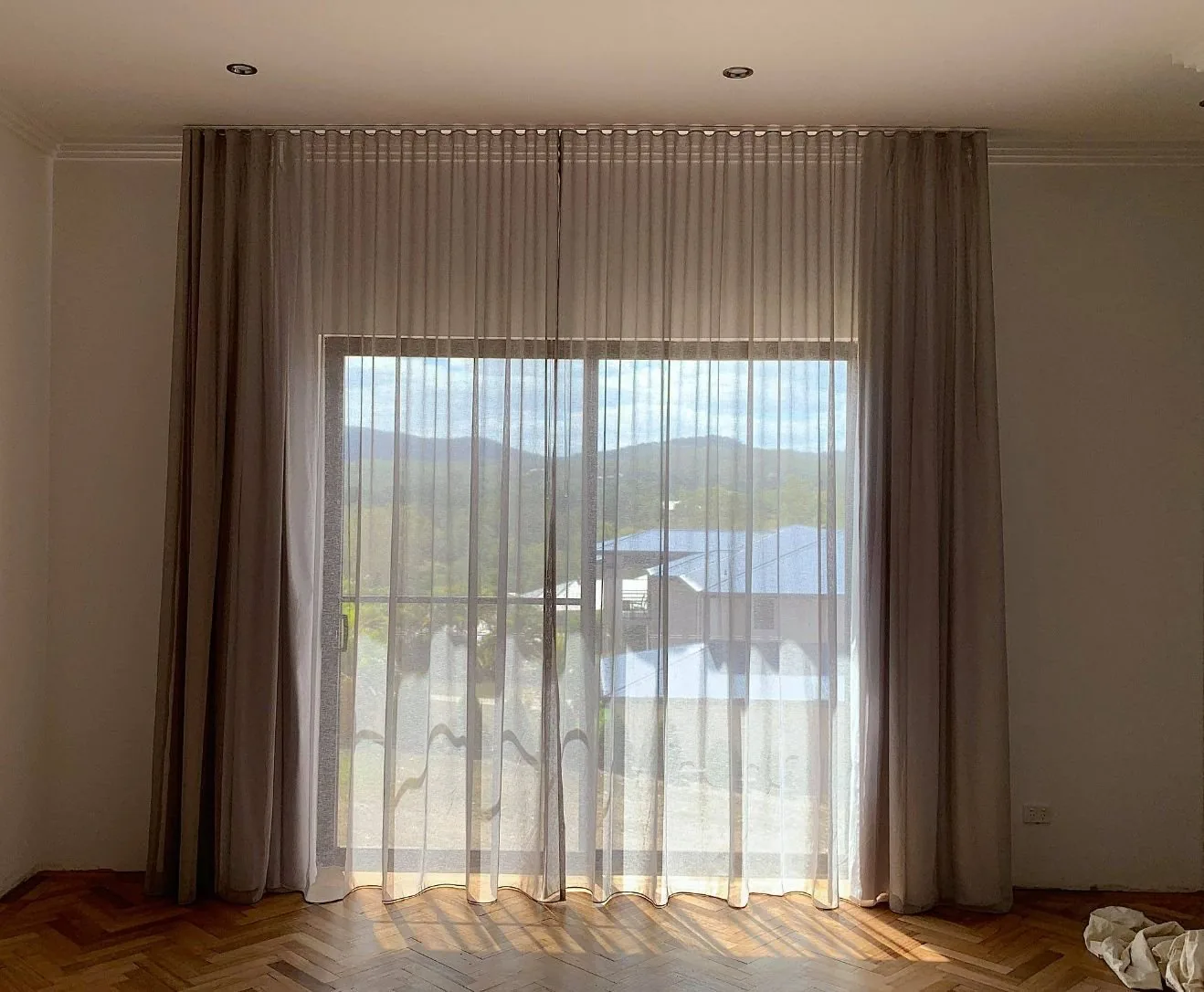 Sheer curtains softening daylight across a glass sliding door